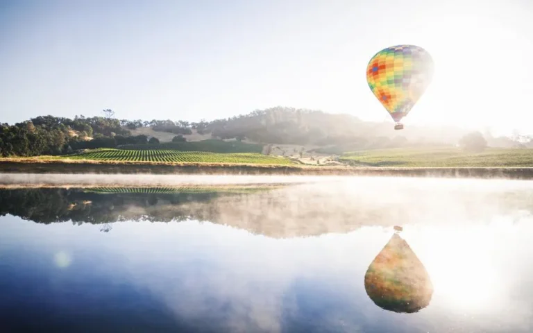 Colorful hot air balloon reflected on lake